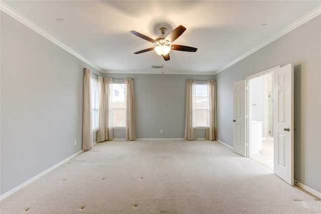 spare room featuring ornamental molding, plenty of natural light, and light colored carpet