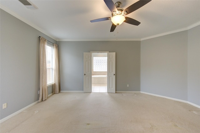 spare room with ceiling fan, ornamental molding, and light carpet