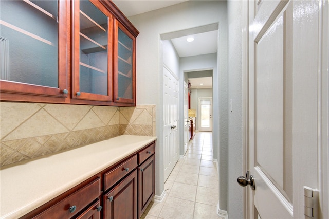 bar featuring light tile patterned floors and decorative backsplash