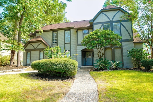 tudor-style house featuring a front yard