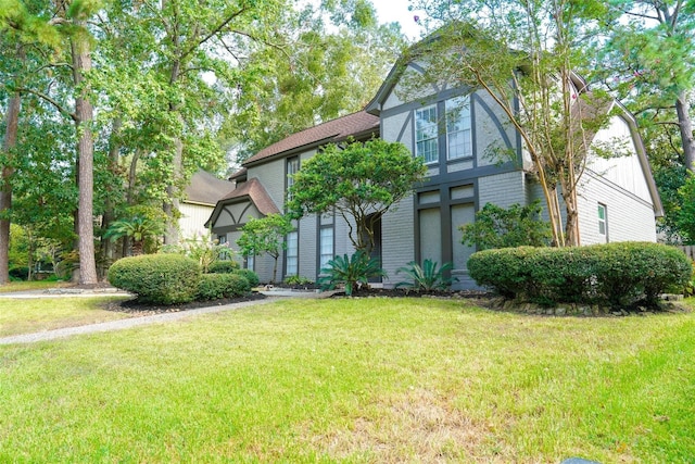 tudor home with a front lawn