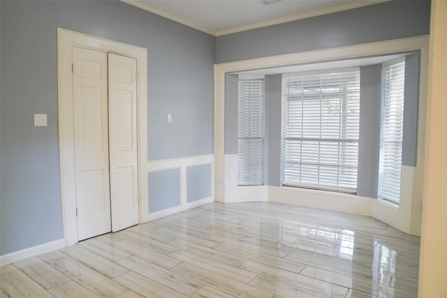 spare room featuring crown molding and light hardwood / wood-style flooring