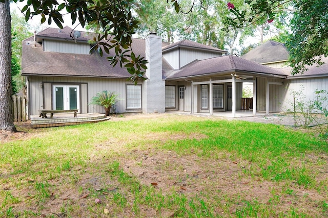 rear view of house with a patio, a lawn, and french doors