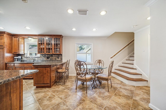 dining room with ornamental molding and sink