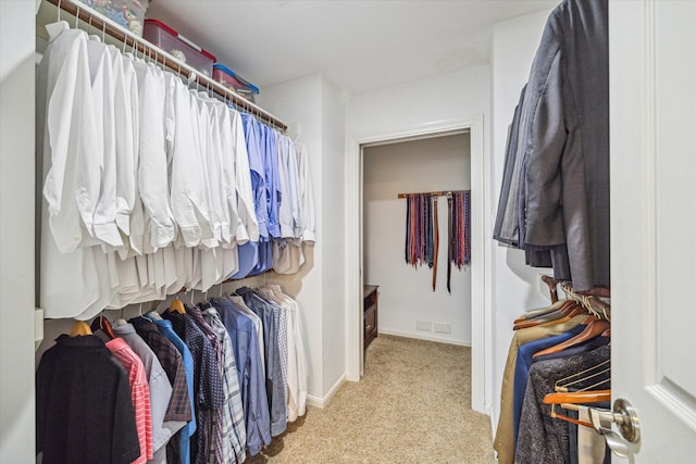 walk in closet featuring light carpet