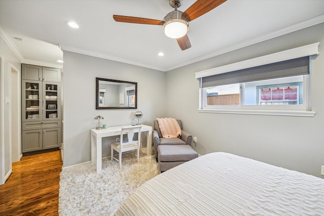 bedroom with crown molding, dark hardwood / wood-style floors, and ceiling fan