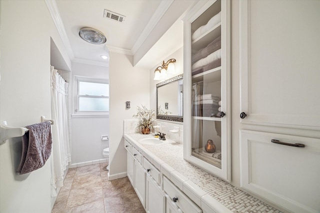 bathroom with vanity, ornamental molding, and toilet