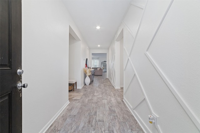 hallway with light hardwood / wood-style floors