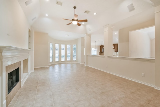 unfurnished living room featuring a tile fireplace, built in features, decorative columns, lofted ceiling, and ceiling fan