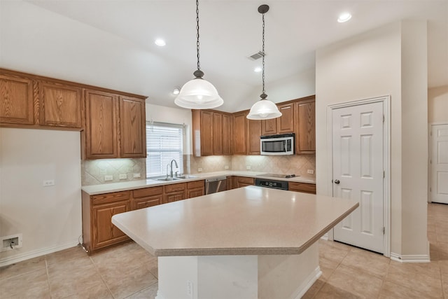 kitchen with sink, hanging light fixtures, stainless steel appliances, a center island, and tasteful backsplash