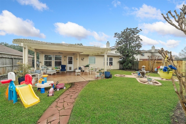 rear view of house with a playground, a yard, a patio area, and a pergola