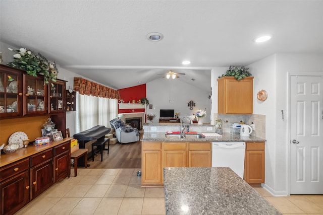 kitchen with light stone countertops, sink, light tile patterned floors, and white dishwasher