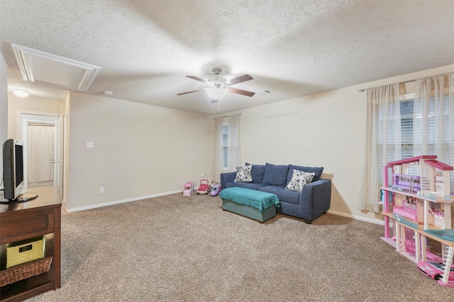 recreation room with ceiling fan, plenty of natural light, a textured ceiling, and carpet