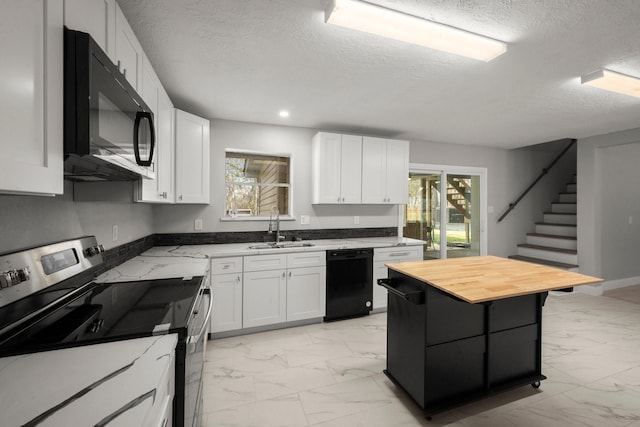 kitchen with butcher block counters, sink, white cabinets, and black appliances