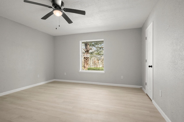 empty room with ceiling fan, light hardwood / wood-style flooring, and a textured ceiling