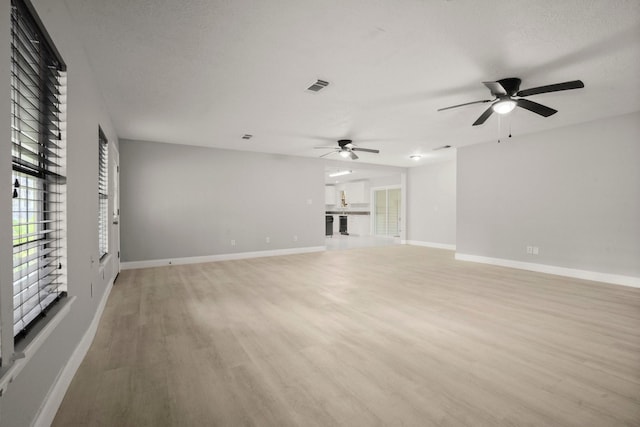 unfurnished living room featuring ceiling fan and light hardwood / wood-style flooring