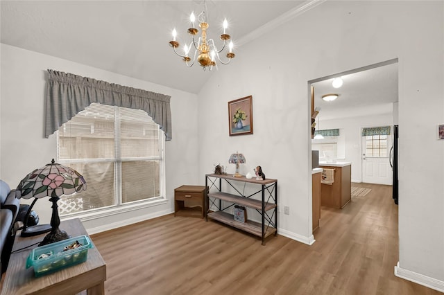 miscellaneous room with lofted ceiling, hardwood / wood-style floors, and a notable chandelier