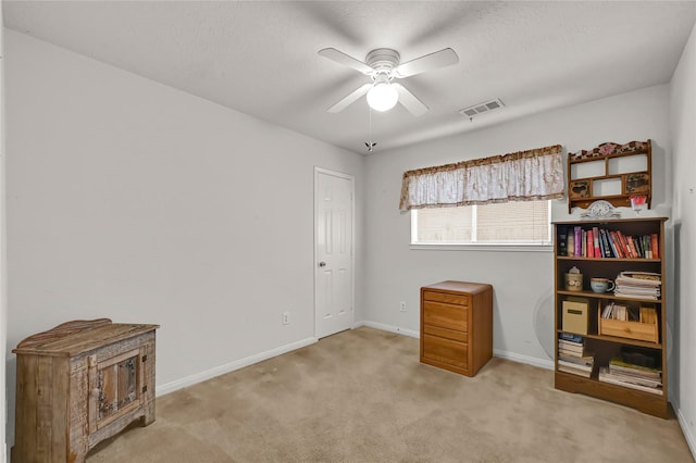 miscellaneous room with ceiling fan, light carpet, and a textured ceiling