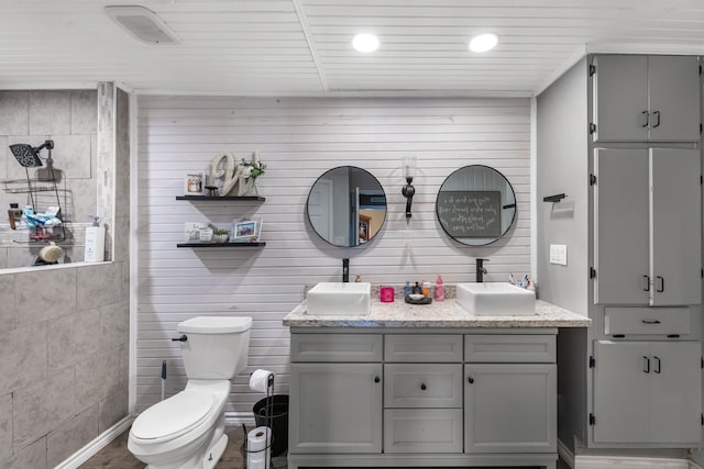 full bath featuring double vanity, toilet, a sink, and recessed lighting