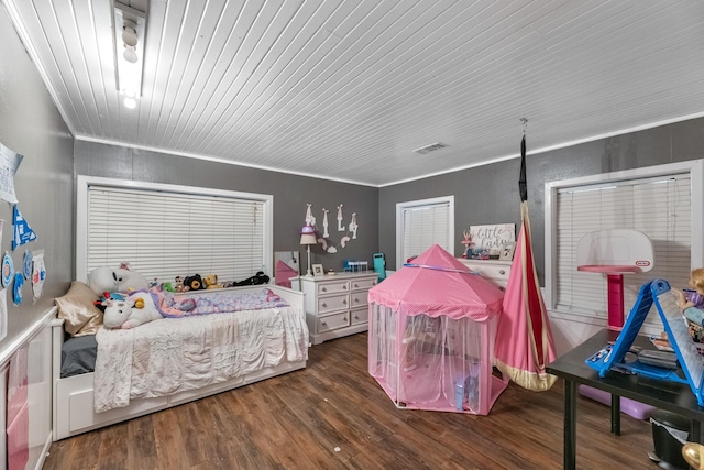 bedroom with ornamental molding, visible vents, and wood finished floors