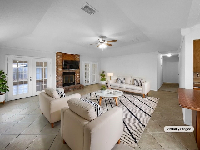 tiled living room featuring a fireplace, french doors, and ceiling fan