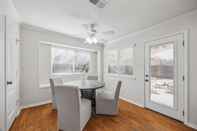 dining area featuring wood-type flooring, ornamental molding, and ceiling fan