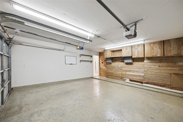 garage with a garage door opener and wooden walls