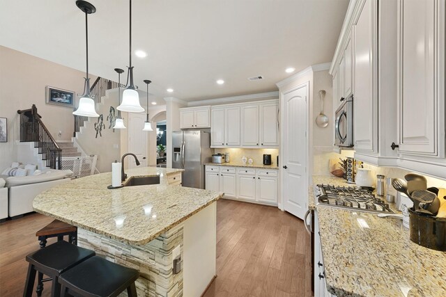 kitchen featuring appliances with stainless steel finishes, a large island, sink, and white cabinets