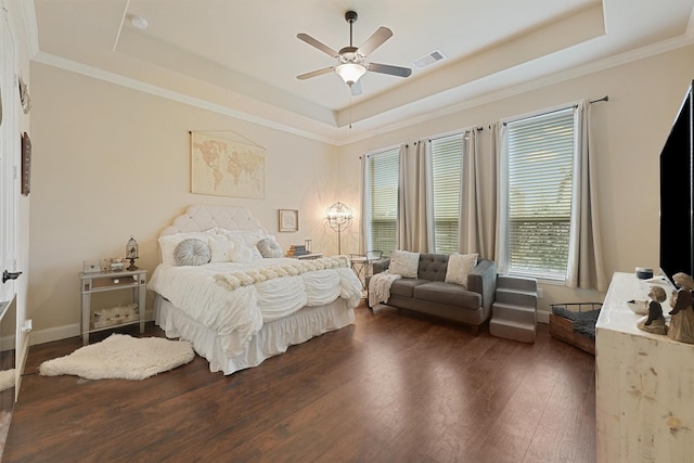 bedroom featuring crown molding, dark hardwood / wood-style floors, a raised ceiling, and ceiling fan