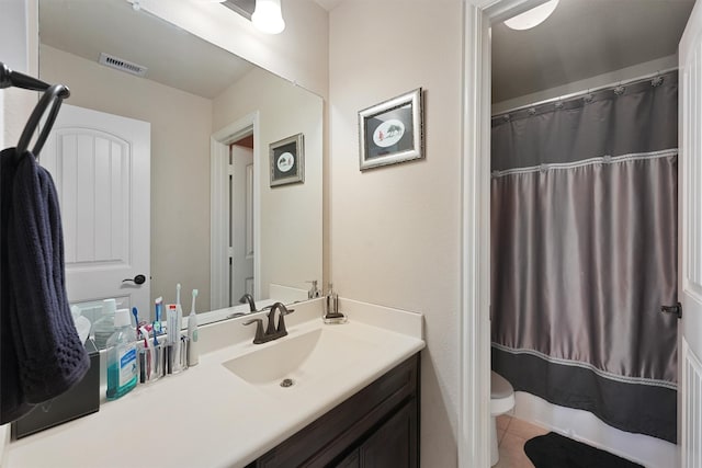 bathroom featuring tile patterned floors, vanity, and toilet