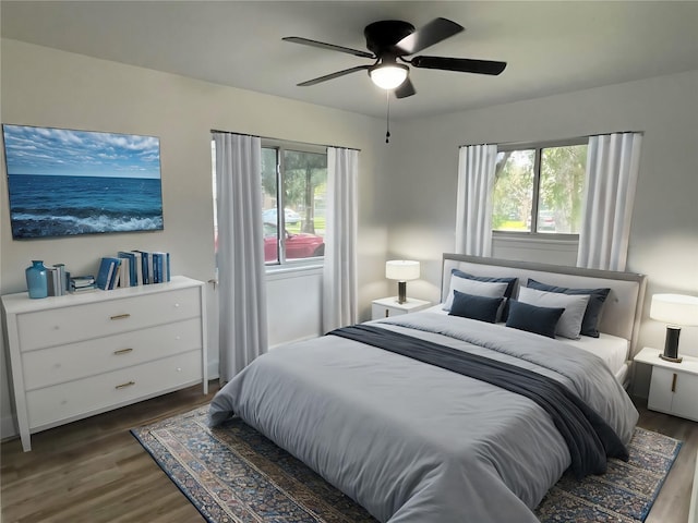 bedroom featuring ceiling fan, dark wood-type flooring, and multiple windows