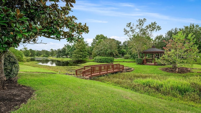 surrounding community with a gazebo, a water view, and a lawn