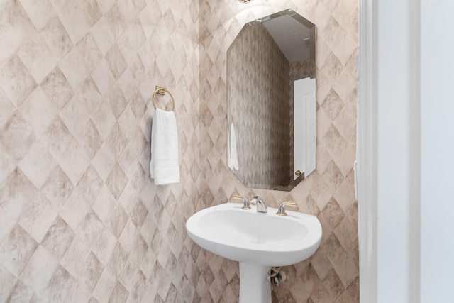 bathroom featuring sink and tile walls