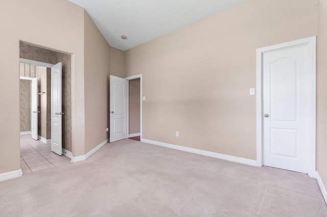 unfurnished bedroom with lofted ceiling and light carpet