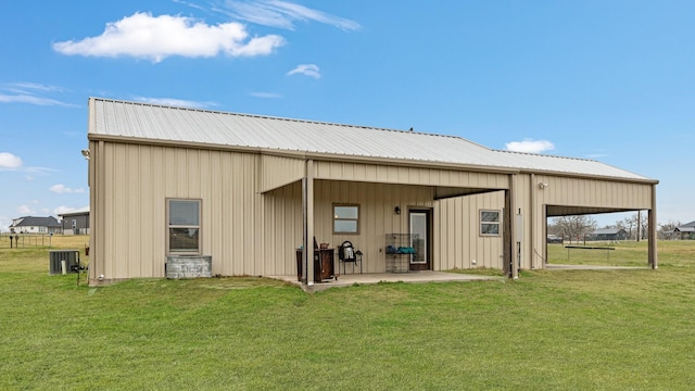 back of house featuring a yard and central AC