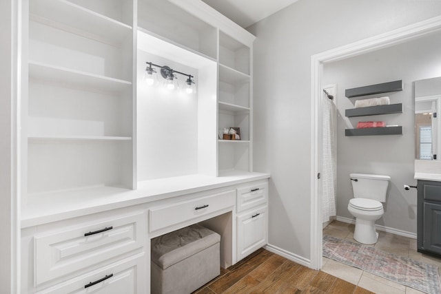 bathroom with hardwood / wood-style flooring, vanity, and toilet