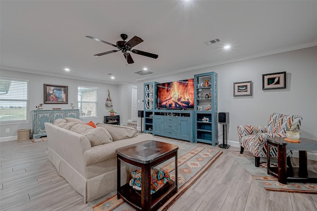 living room with ceiling fan, ornamental molding, and light hardwood / wood-style flooring