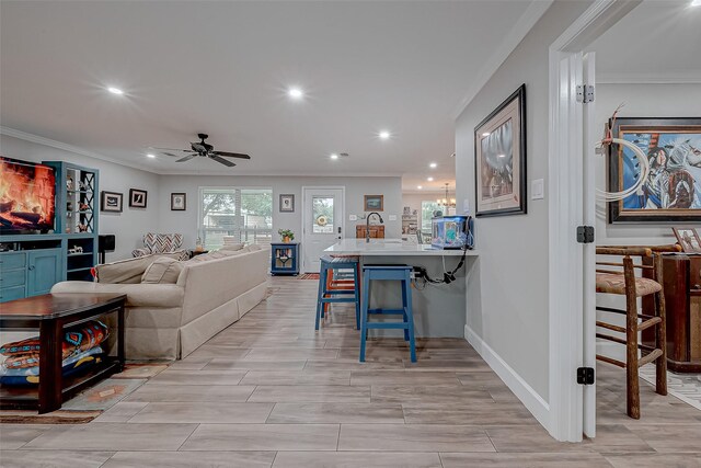 living room featuring crown molding and ceiling fan with notable chandelier