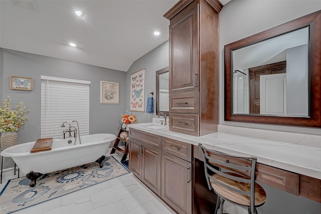 bathroom featuring vanity, vaulted ceiling, and a bathing tub