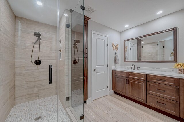 bathroom featuring walk in shower and vanity