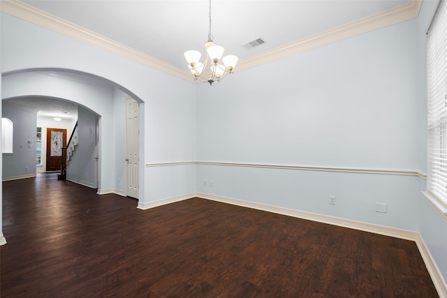 unfurnished room with crown molding, dark hardwood / wood-style floors, and a chandelier