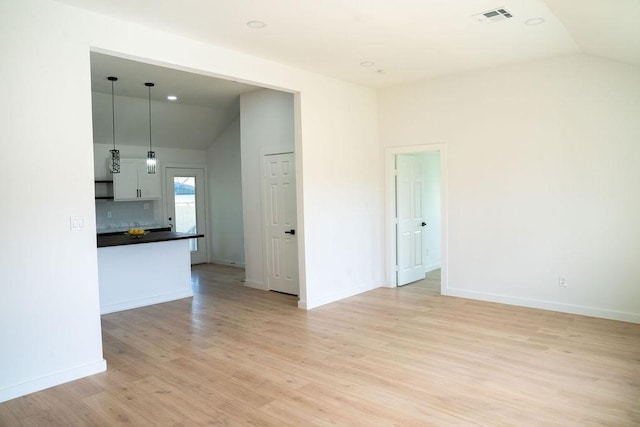 interior space featuring lofted ceiling and light hardwood / wood-style floors