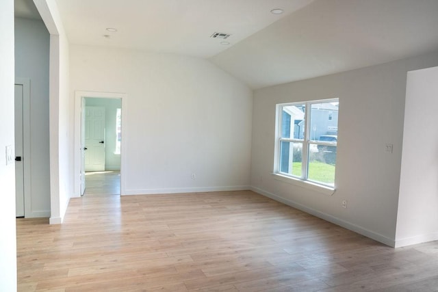 empty room with lofted ceiling and light wood-type flooring