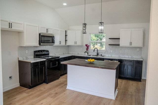 kitchen featuring wood counters, decorative light fixtures, sink, a center island, and black range with electric stovetop