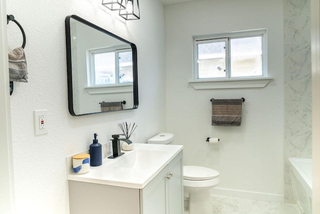 bathroom featuring vanity, a washtub, and toilet