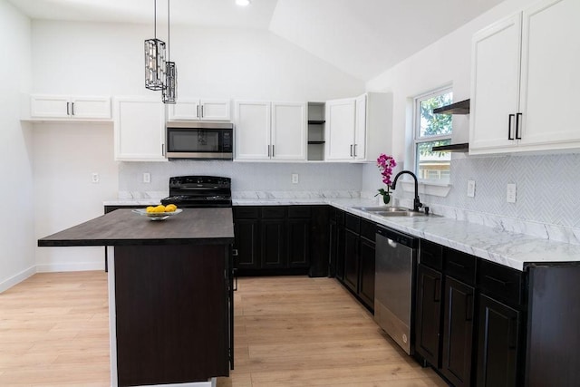 kitchen with vaulted ceiling, a kitchen island, sink, hanging light fixtures, and stainless steel appliances