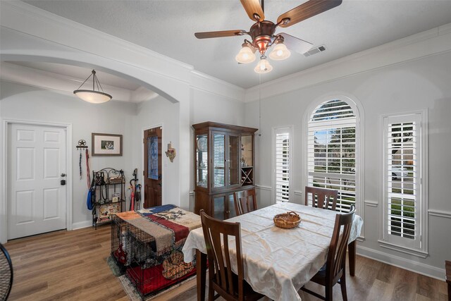 dining area featuring crown molding, dark wood-type flooring, and ceiling fan