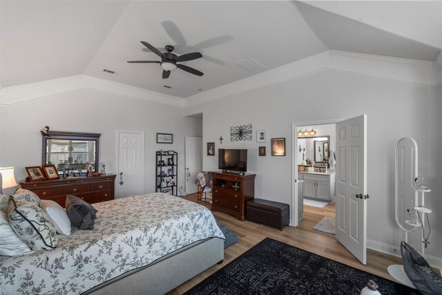 bedroom featuring ceiling fan, lofted ceiling, connected bathroom, and light hardwood / wood-style floors