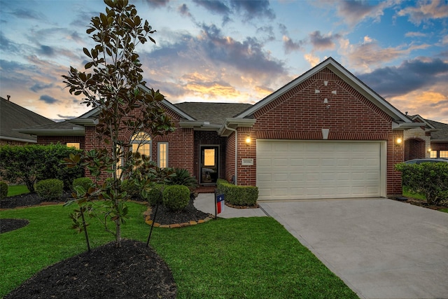 view of front of property featuring a garage and a yard