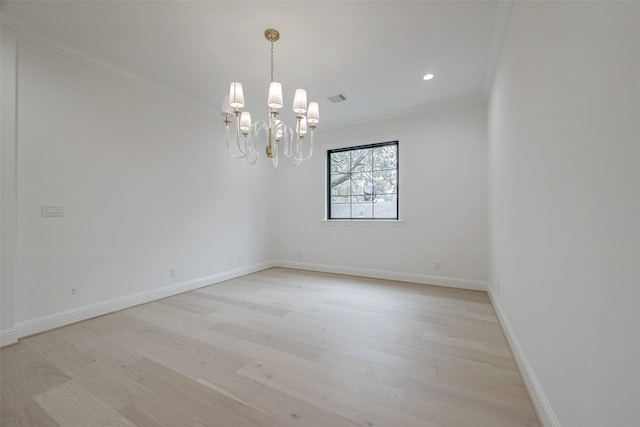 empty room with crown molding, a chandelier, and light wood-type flooring